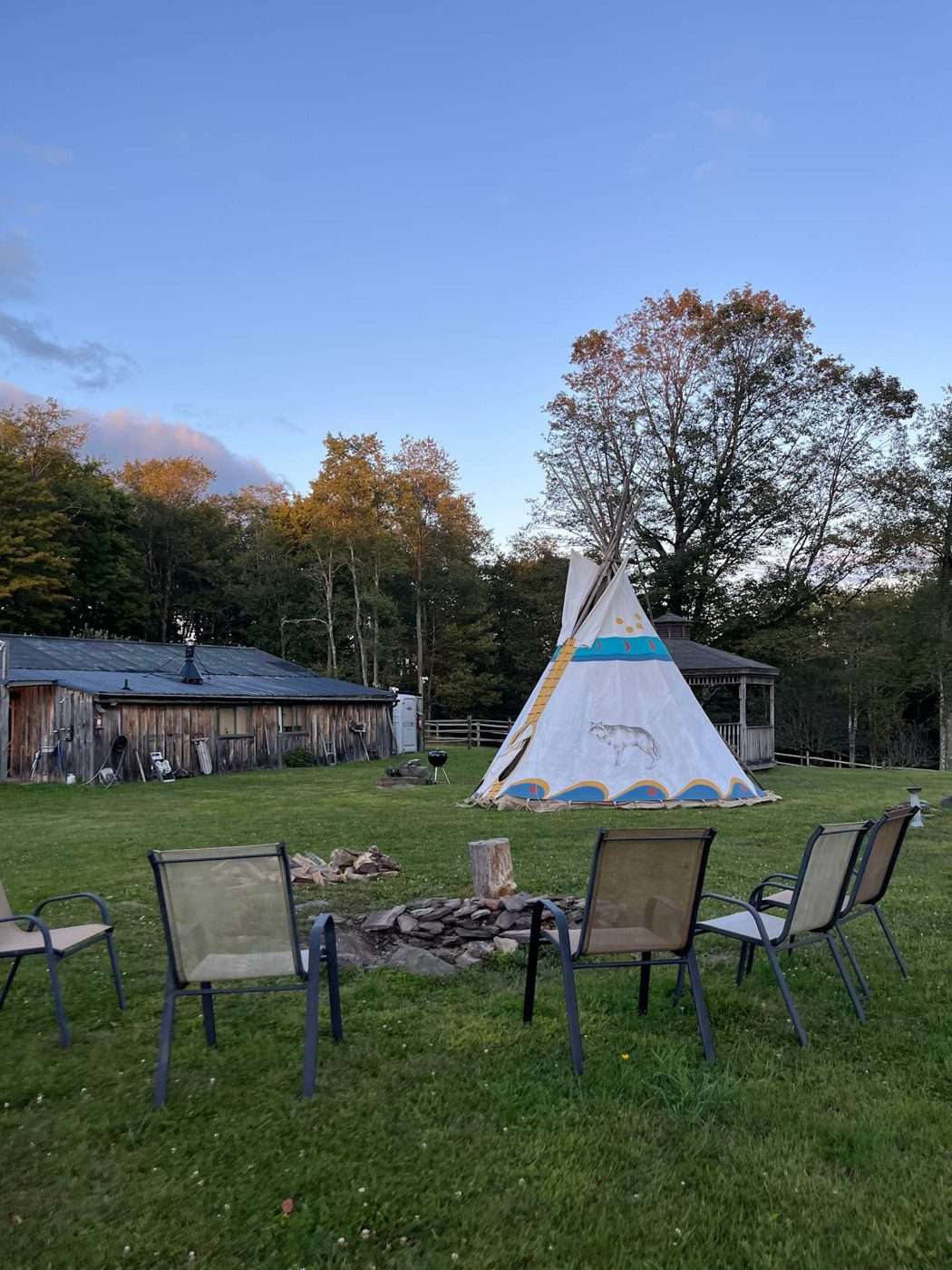 Camp chairs set out in front of the teepee at dusk at Namaste Catskills